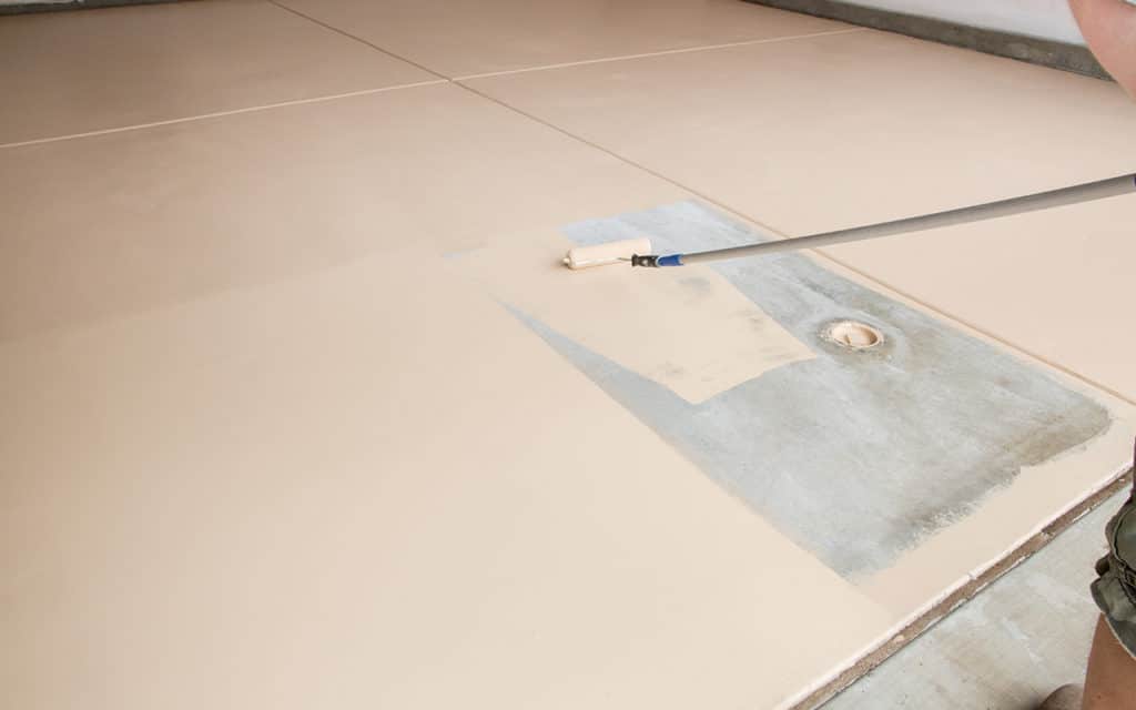 paint roller painting garage floor